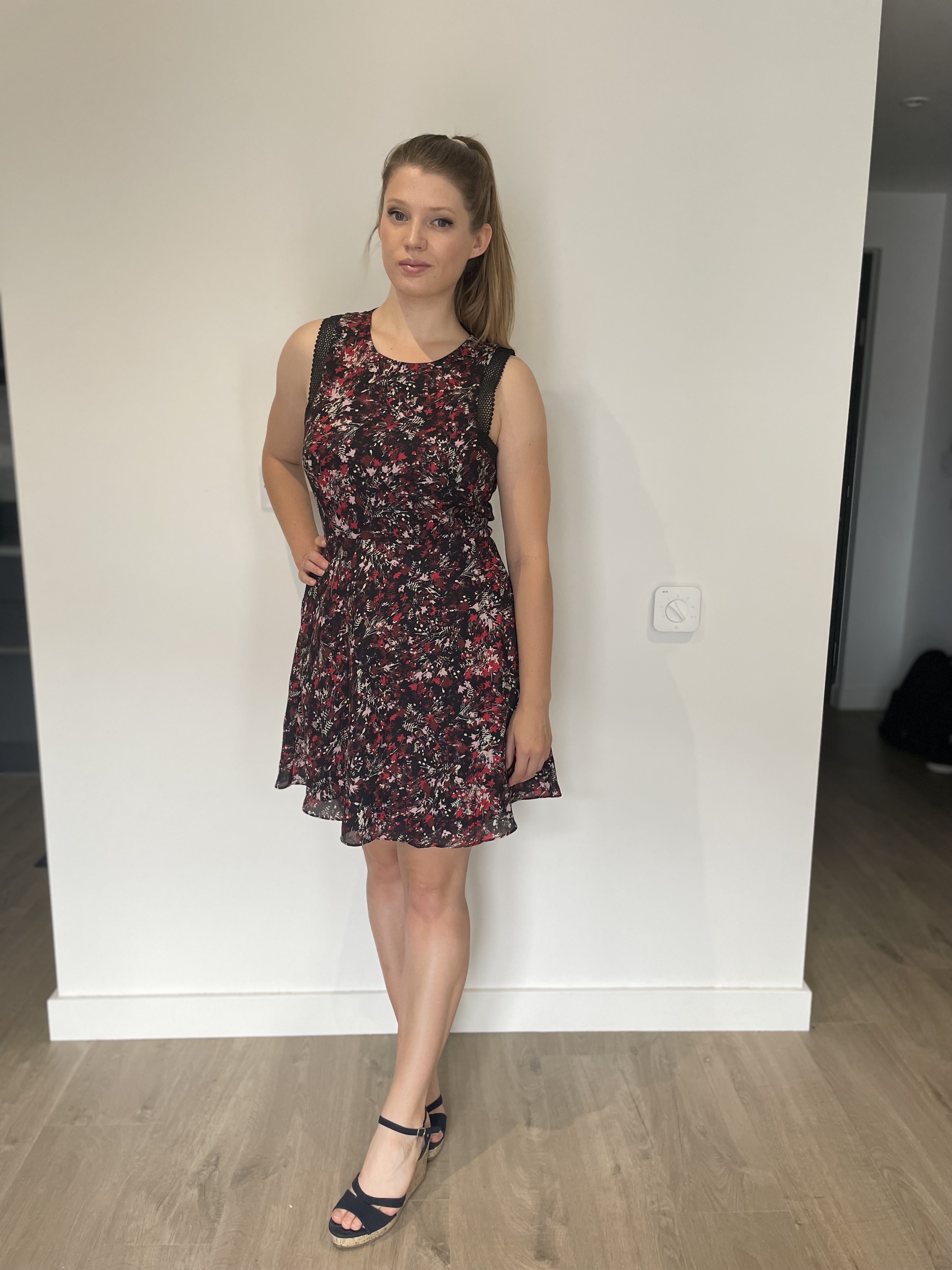 Outfit is a red and black patterned dress with blue wedge sandals