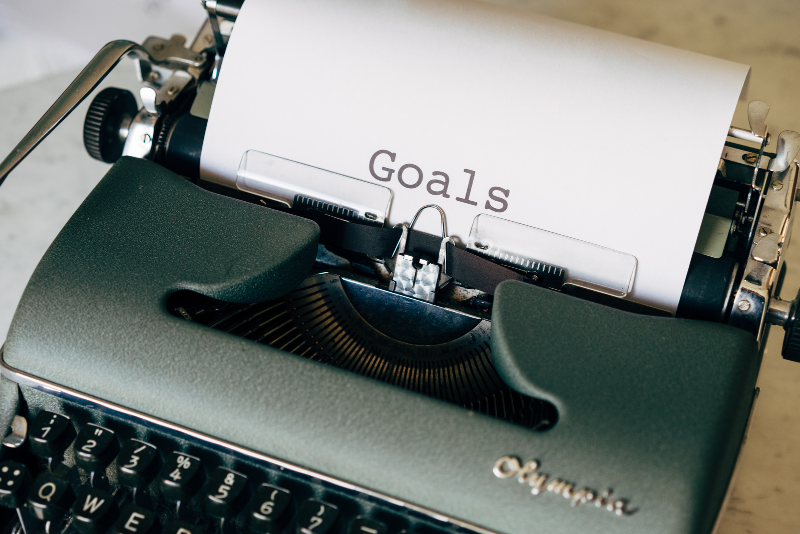 A type writer with 'Goals' typed on the paper.