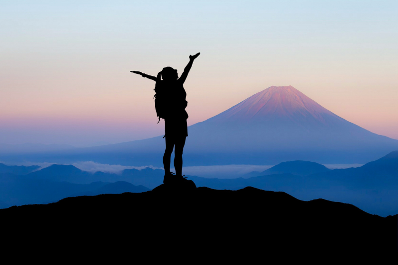 A woman stood on the summit of a mountain.