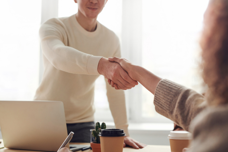 A handshake over a work desk.